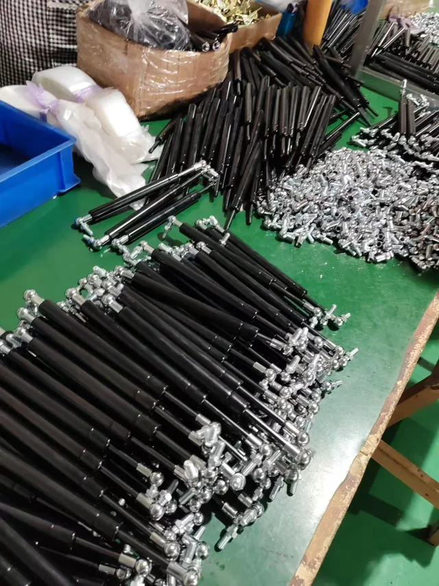 Gas springs with ball-joint connections at an assembly station